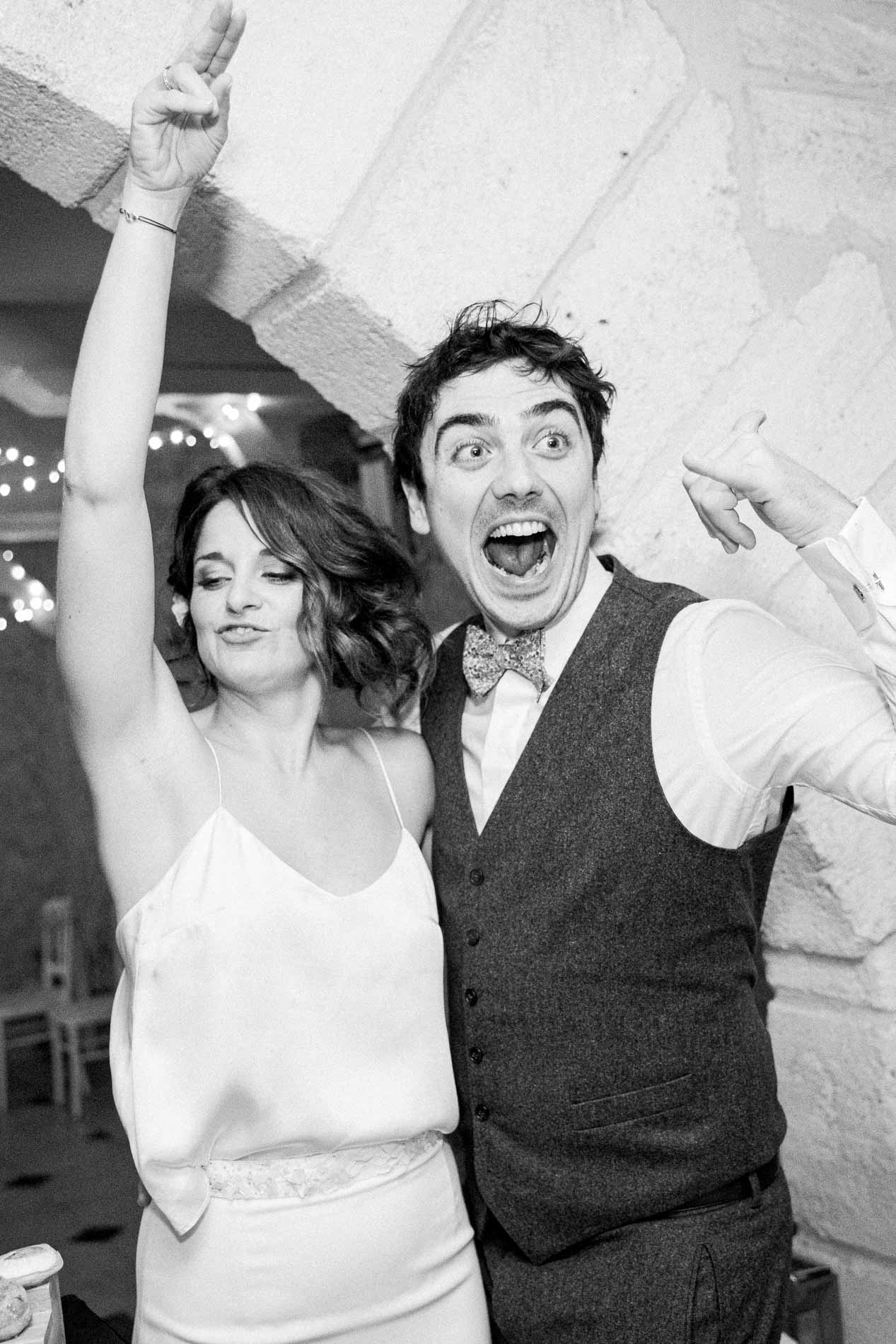 The bride and groom partying on the dance floor, in black and white