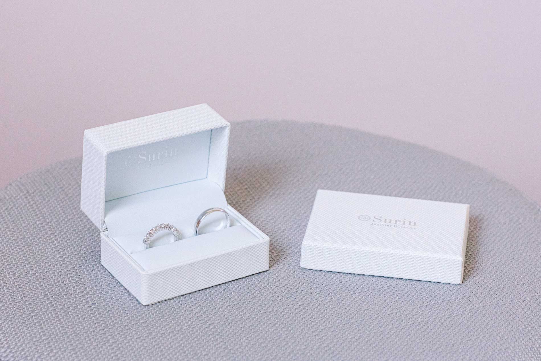 Wedding rings in a white ring box on a table before the ceremony