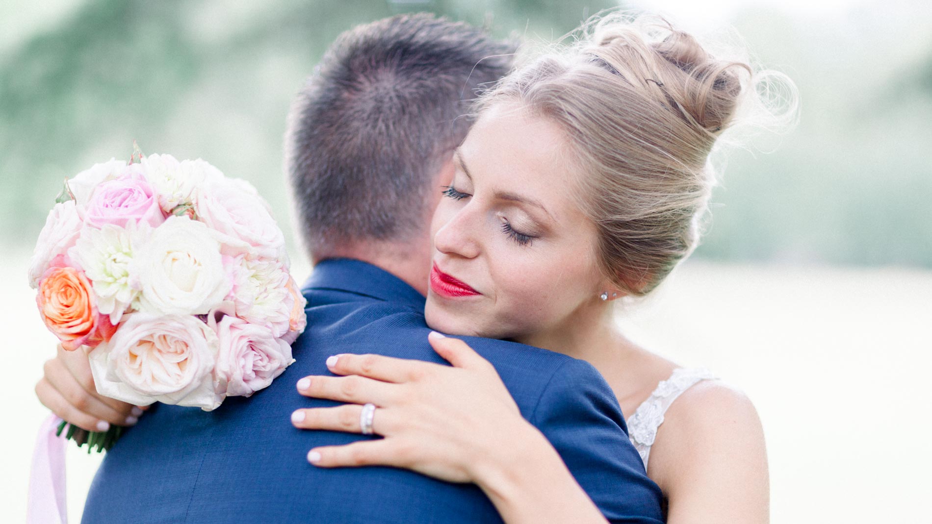 Bride hugging the groom with her pastel rose bouquet in hand