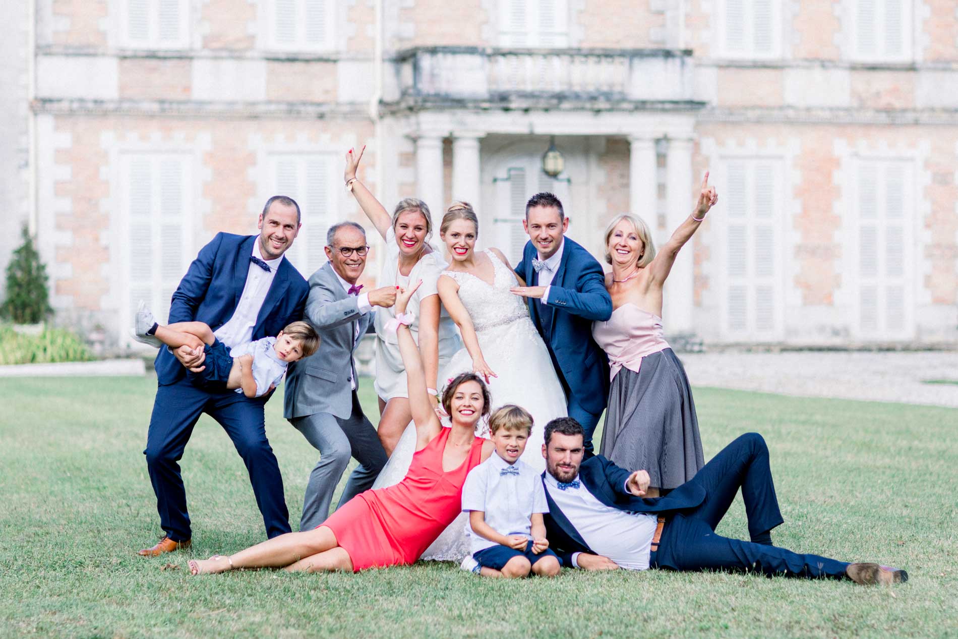 Playful group photo of the newlyweds and their loved ones outside Château de Cujac