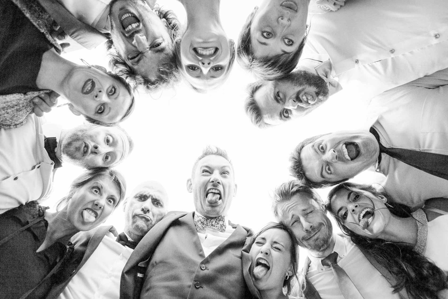 Guests pulling funny faces in a circle above the camera, black and white group shot