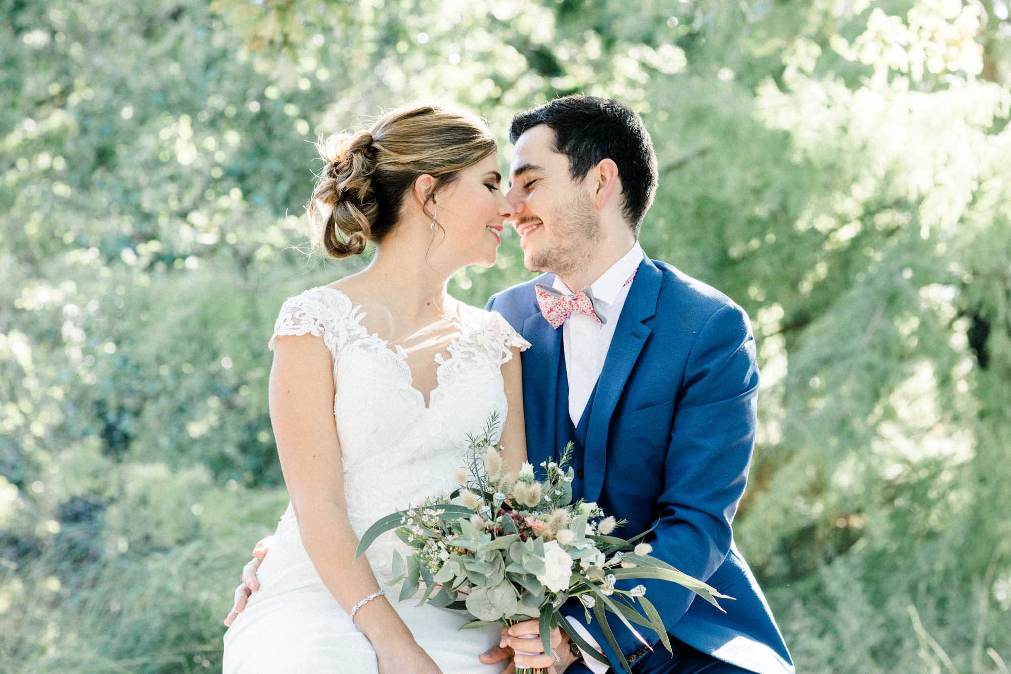 Couple in wedding attire forehead to forehead in Parc de Majolan during a couple session