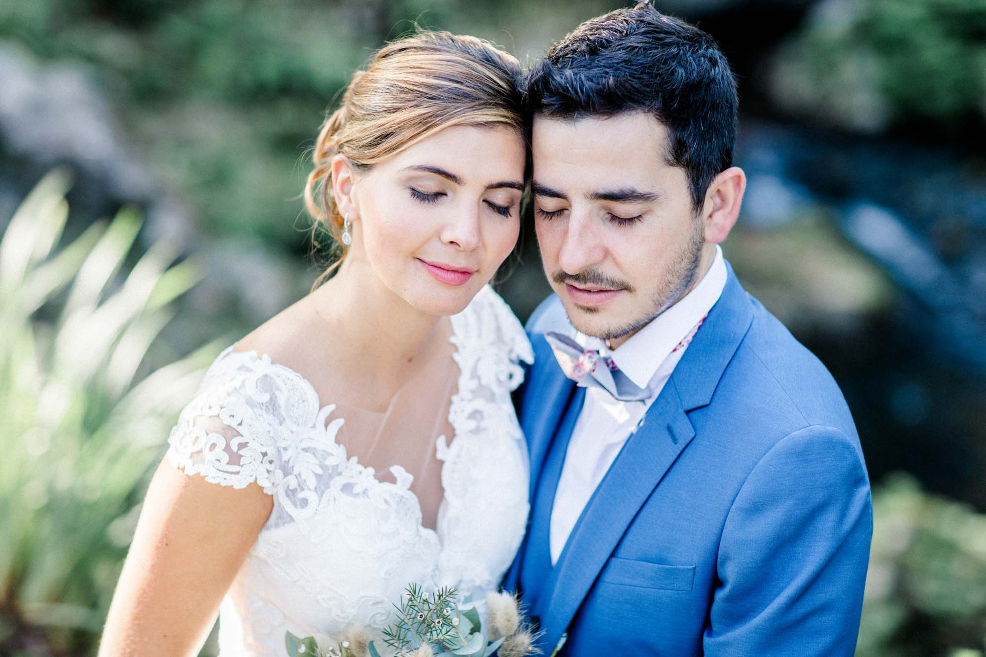 Couple head to head, the bride with eyes closed, in soft light