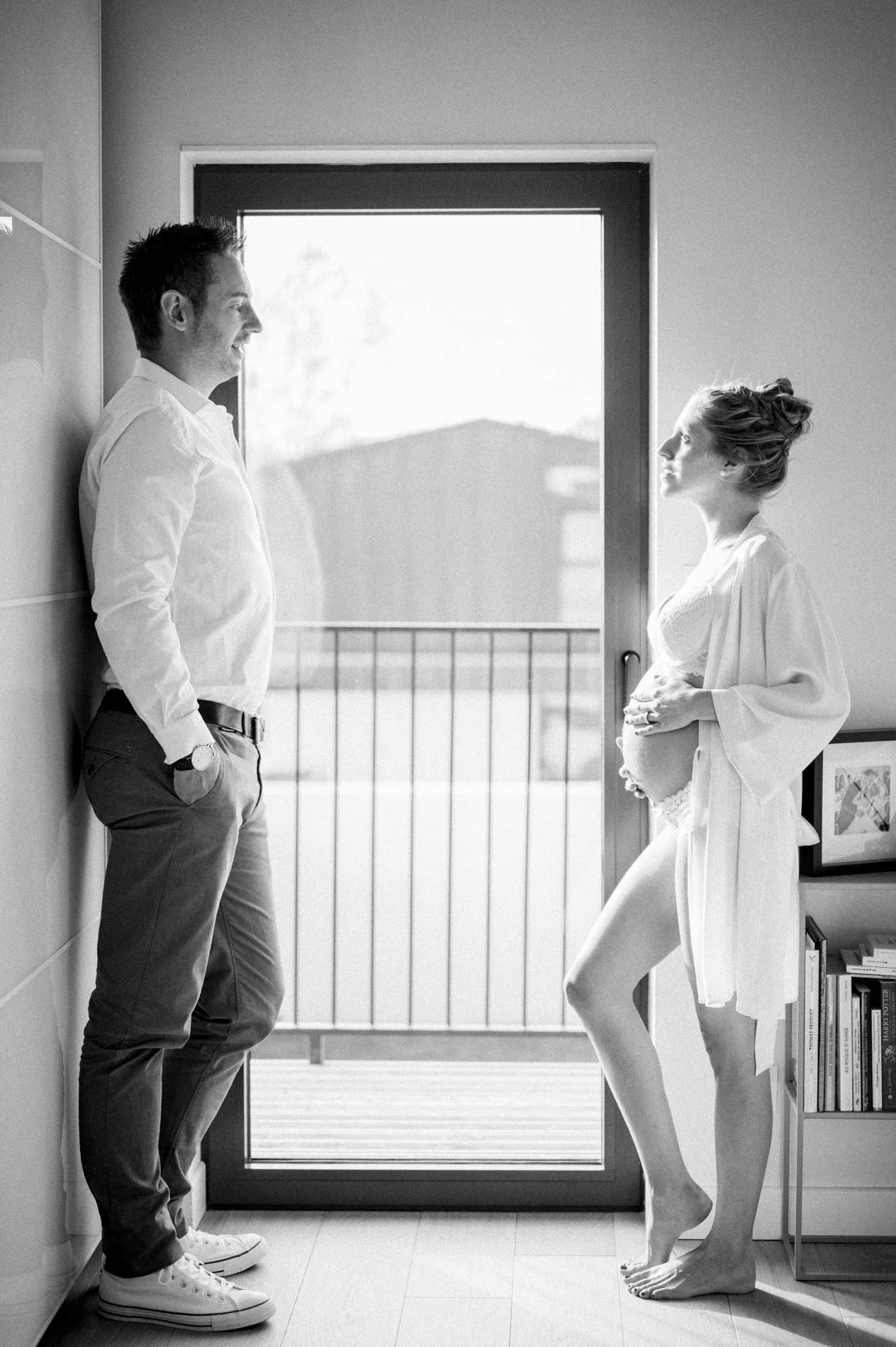 Johanna and Alexandre facing each other by the glass door, in black and white