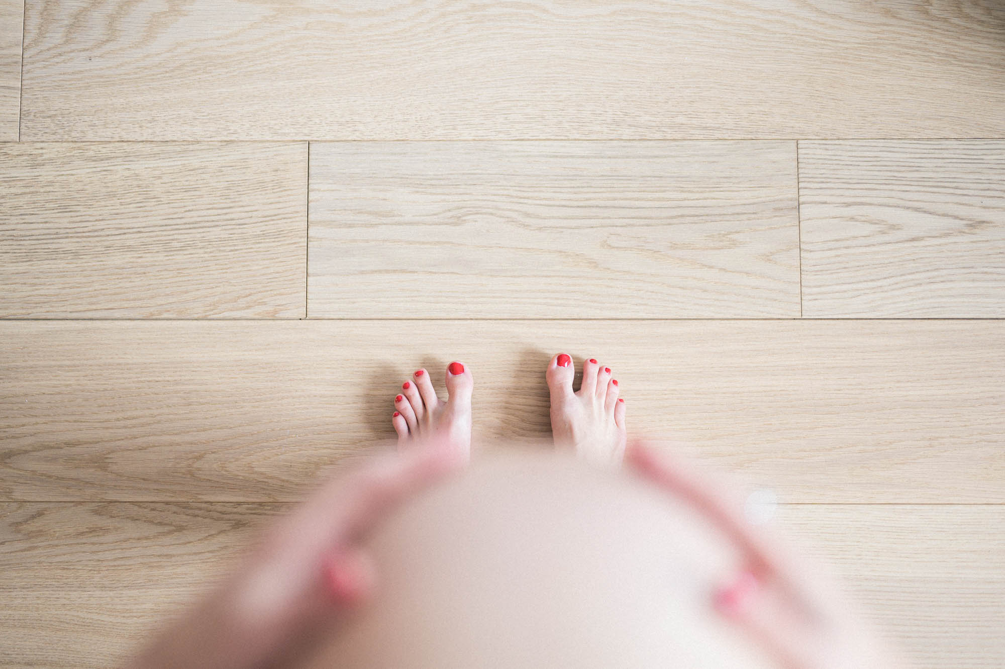 Looking down over Johanna's bump to her feet on the wooden floor