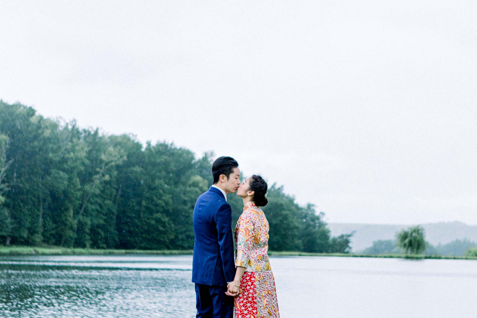 Cherrine and Gary kissing by the lake at Château des Vigiers in the Dordogne