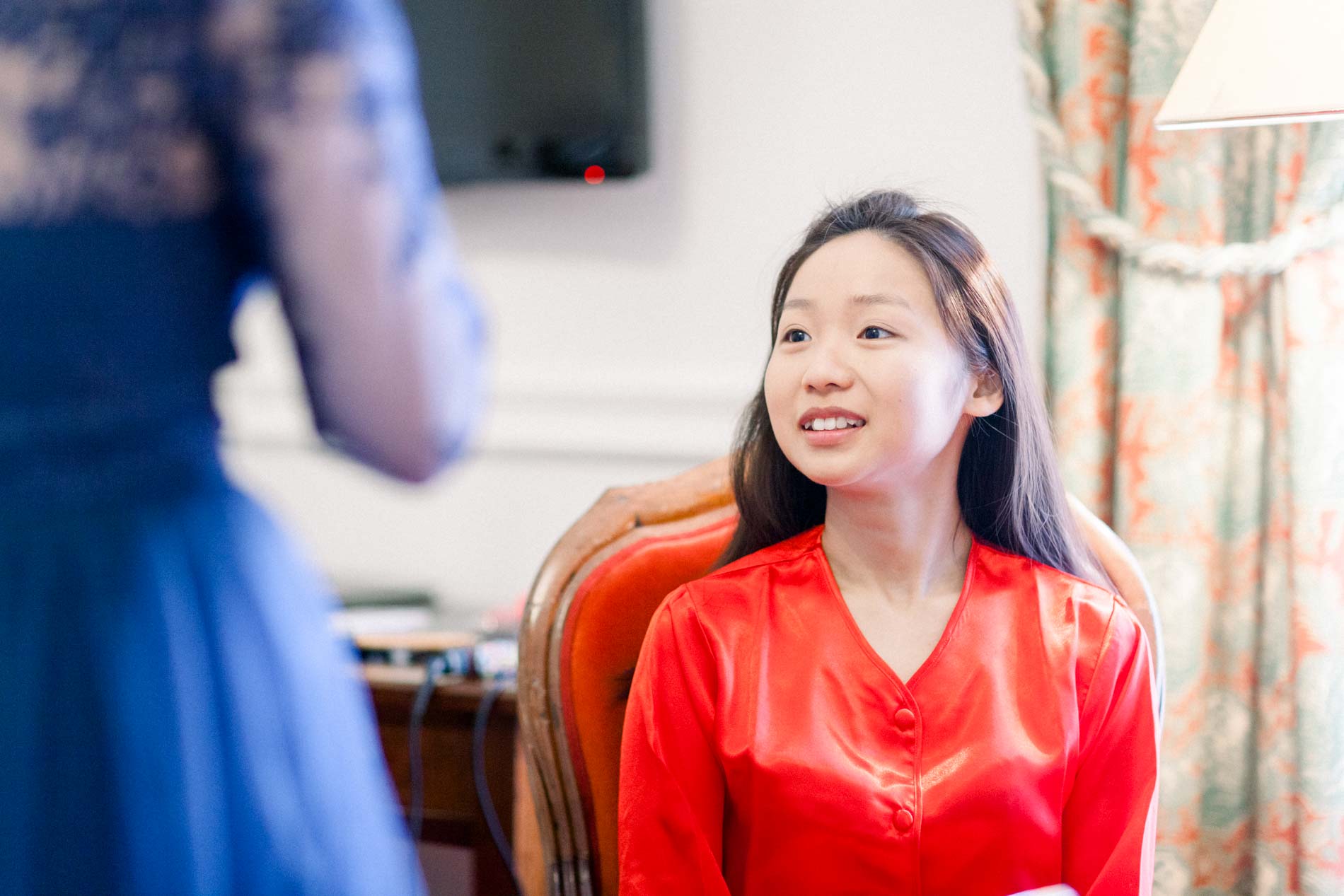 Young woman in a red blouse smiling during the preparations