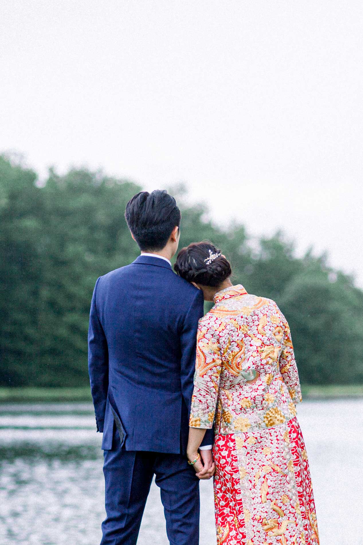 The couple from behind facing the lake, her head on his shoulder