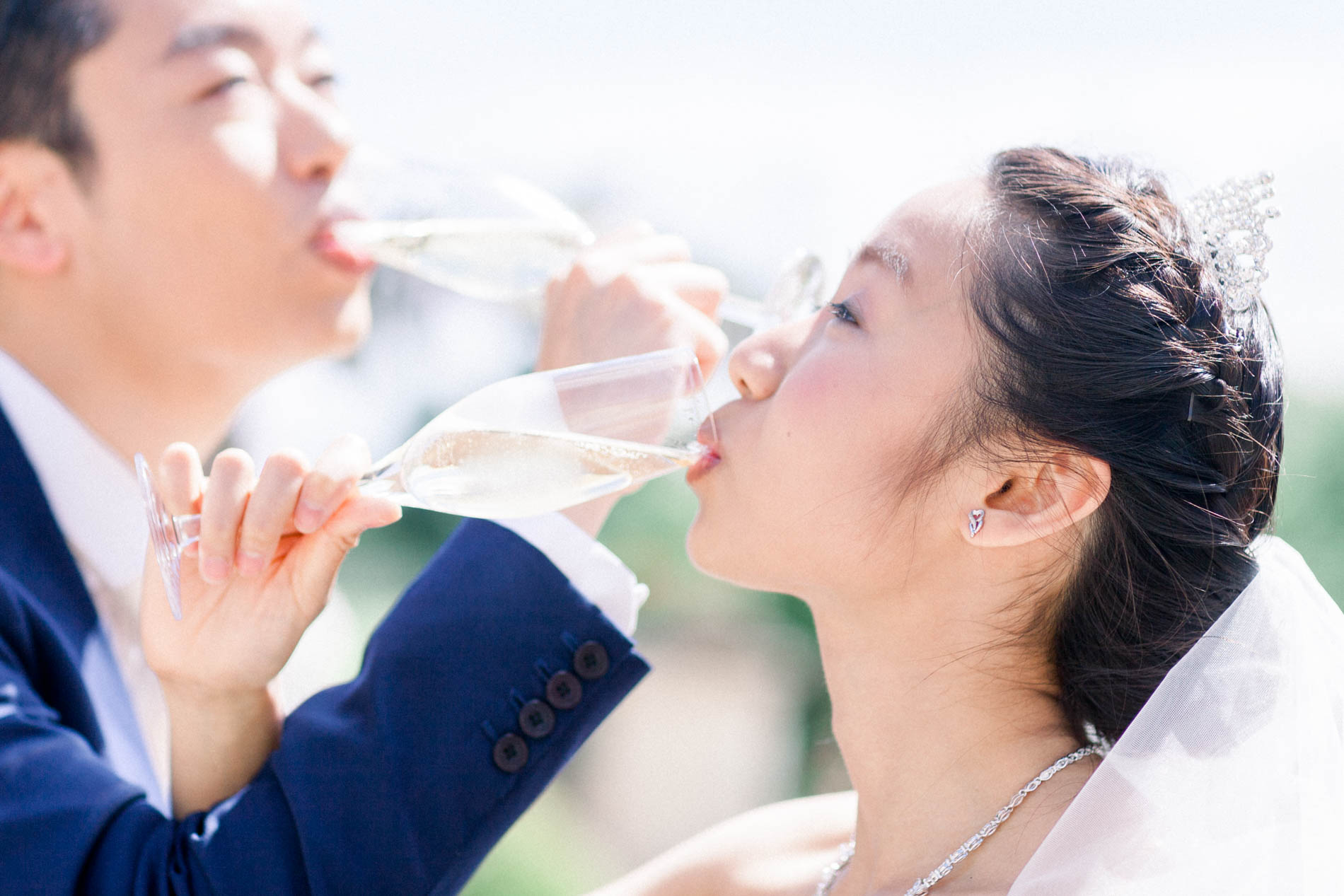 Bride and groom drinking champagne with linked arms