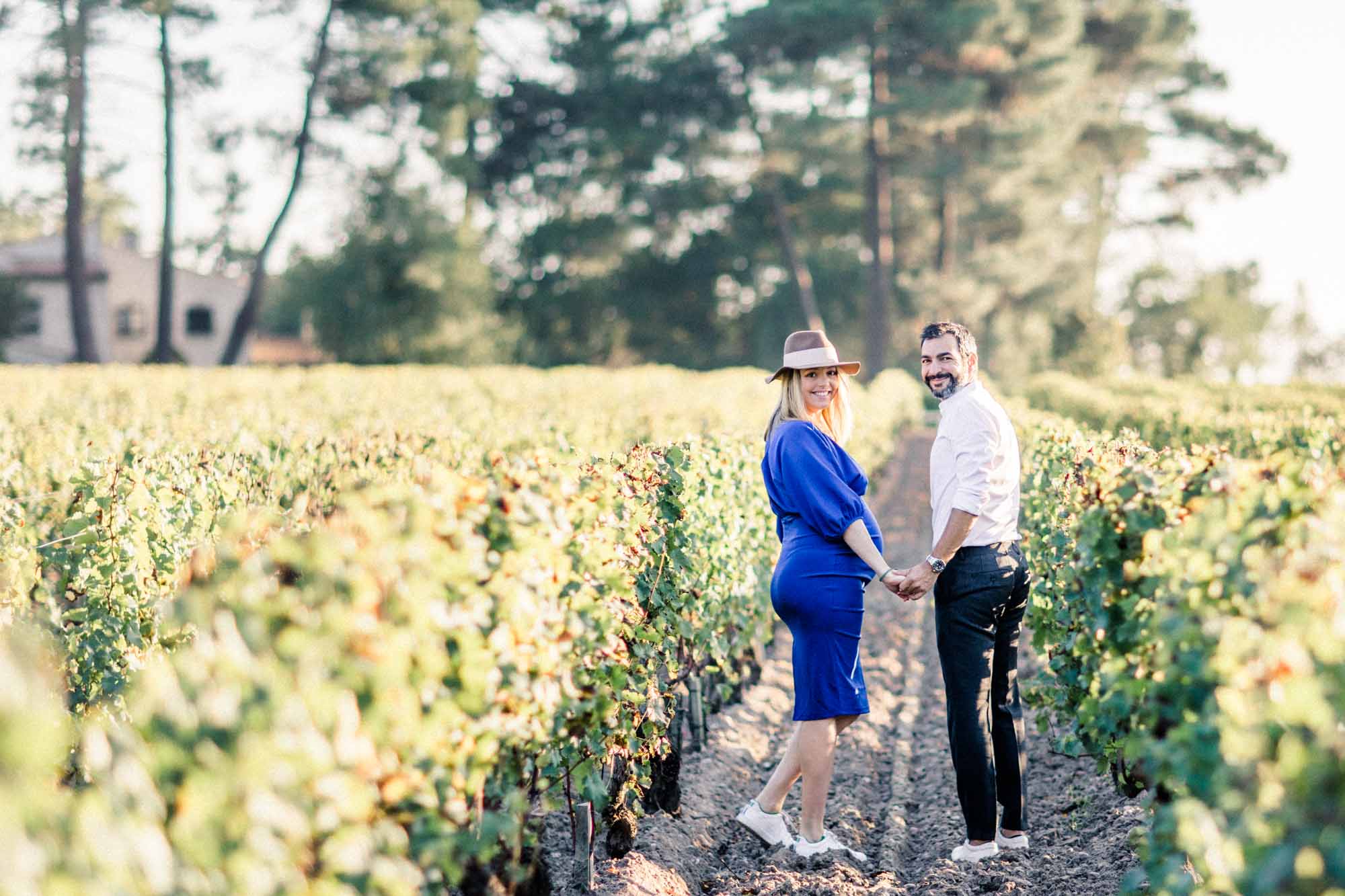 The couple hand in hand in a vine row at Smith Haut Lafitte