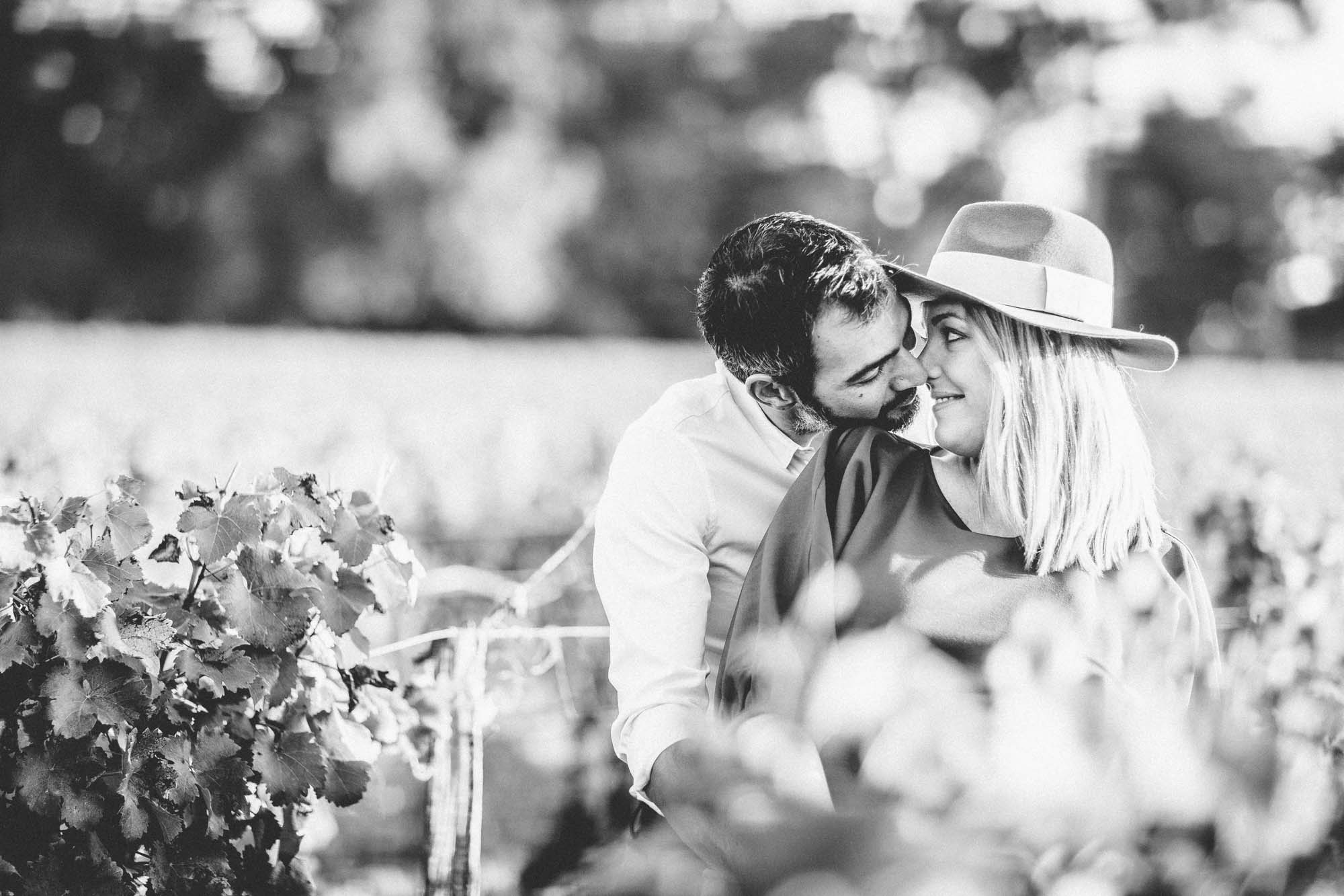 The couple in a tender embrace in the vines, in black and white