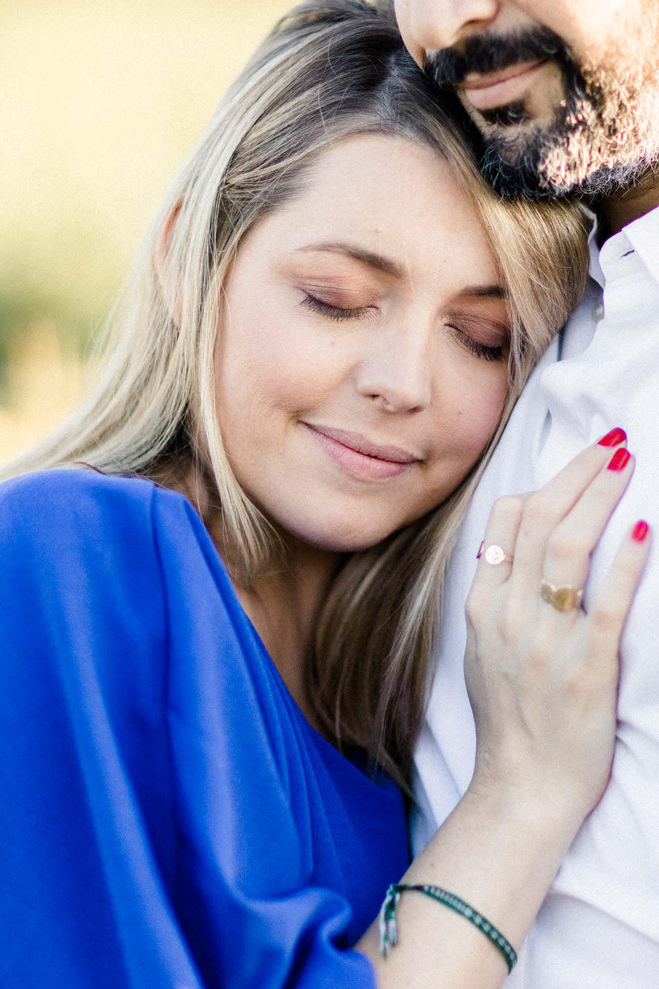 The mother-to-be with eyes closed, nestled against the father-to-be