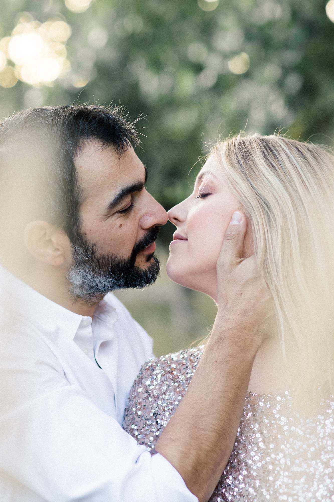 The couple nose to nose, his hand cradling her face