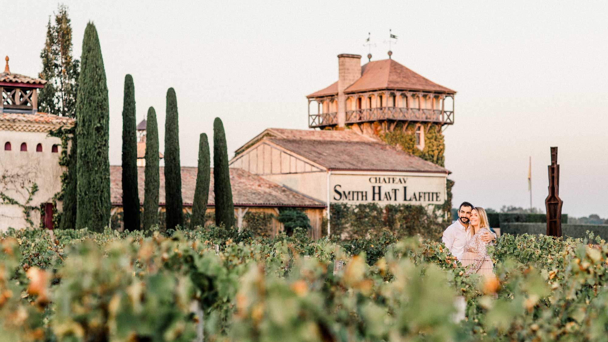 The couple in the vines in front of the Château Smith Haut Lafitte tower