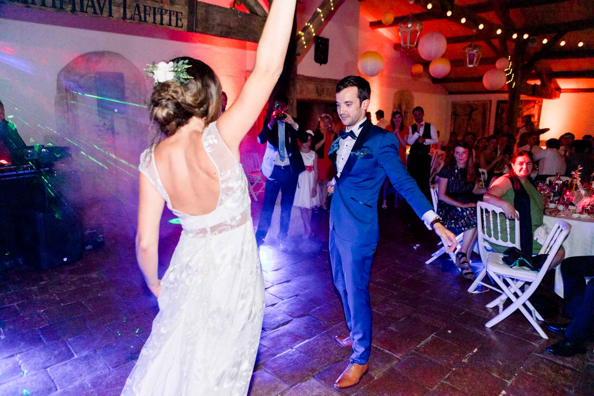 Bride raising her arm while dancing opposite the groom
