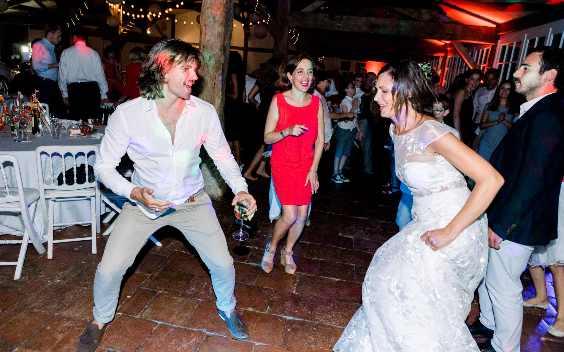 Bride and guests dancing energetically on the dance floor