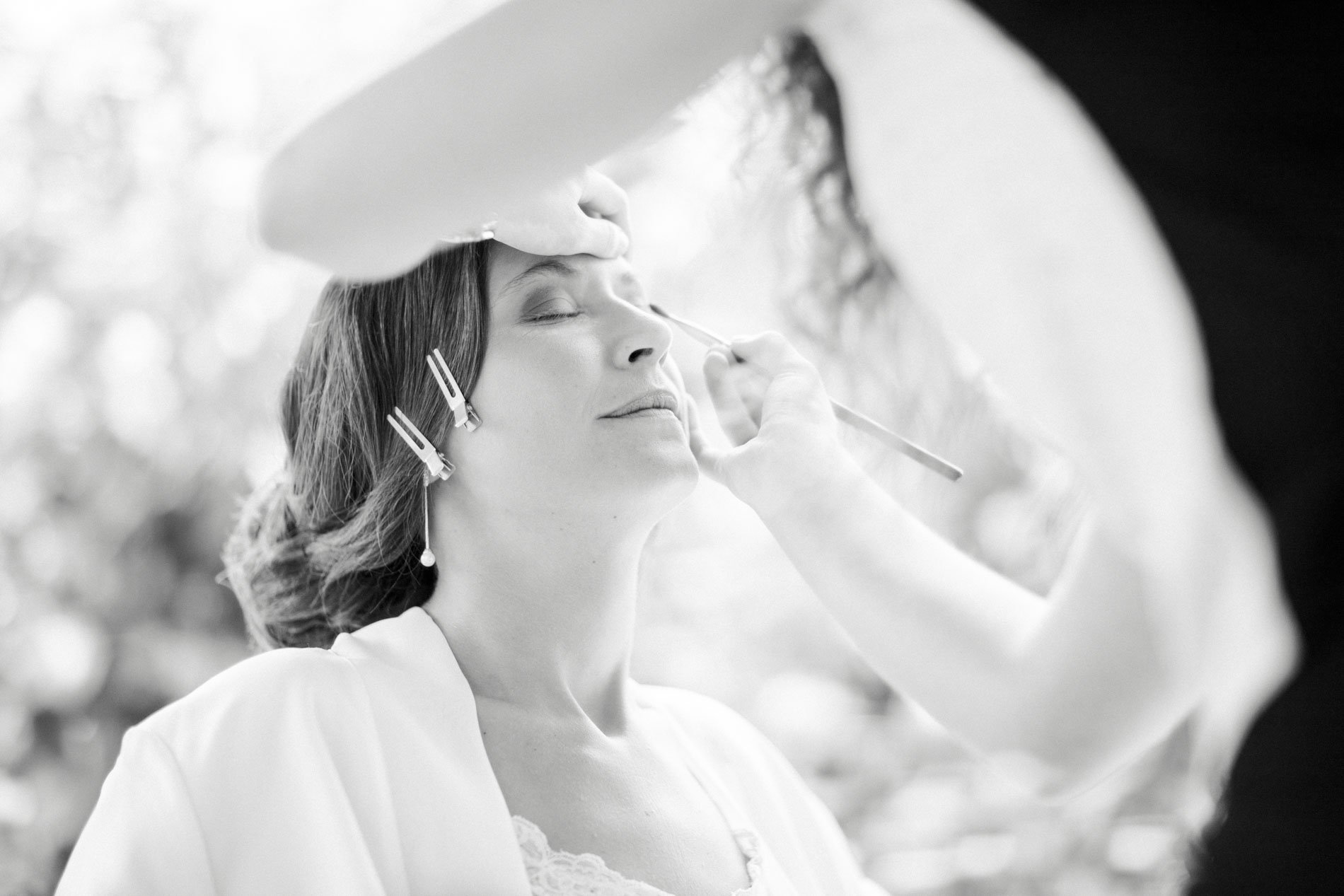 The bride's make-up being done during preparations, black and white
