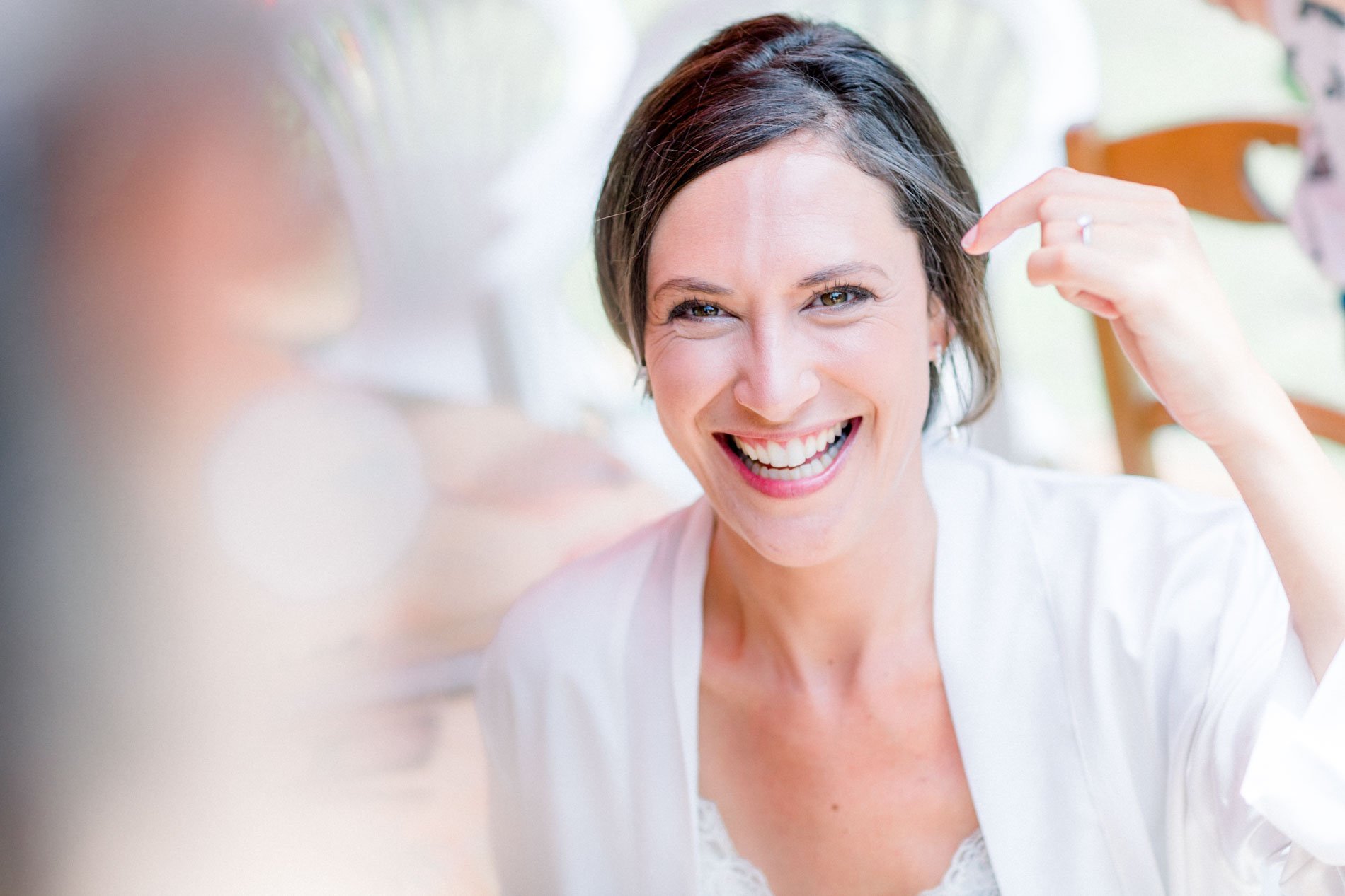 Bride laughing as her hair is adjusted