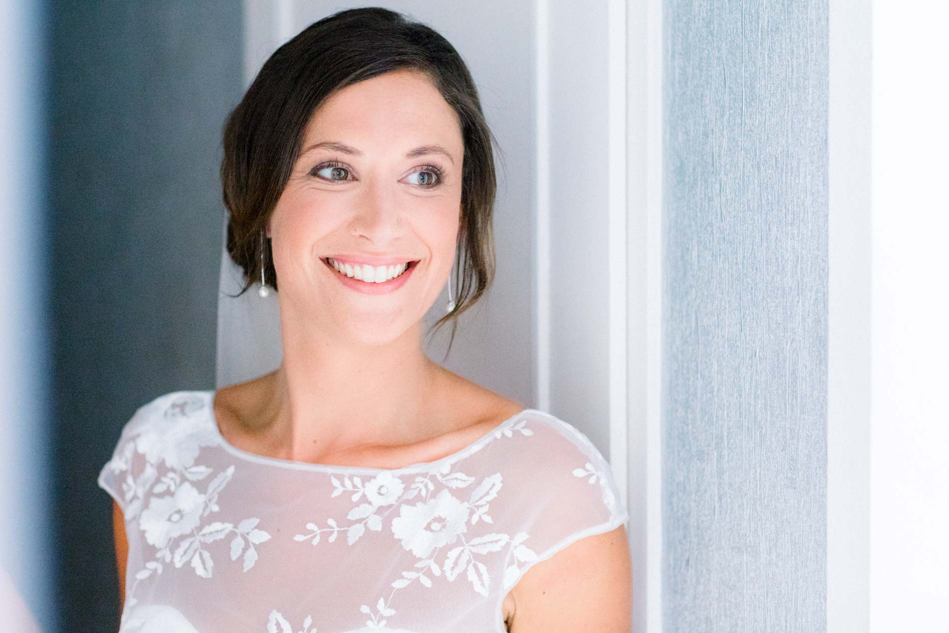 Smiling bride portrait against a pale blue shutter