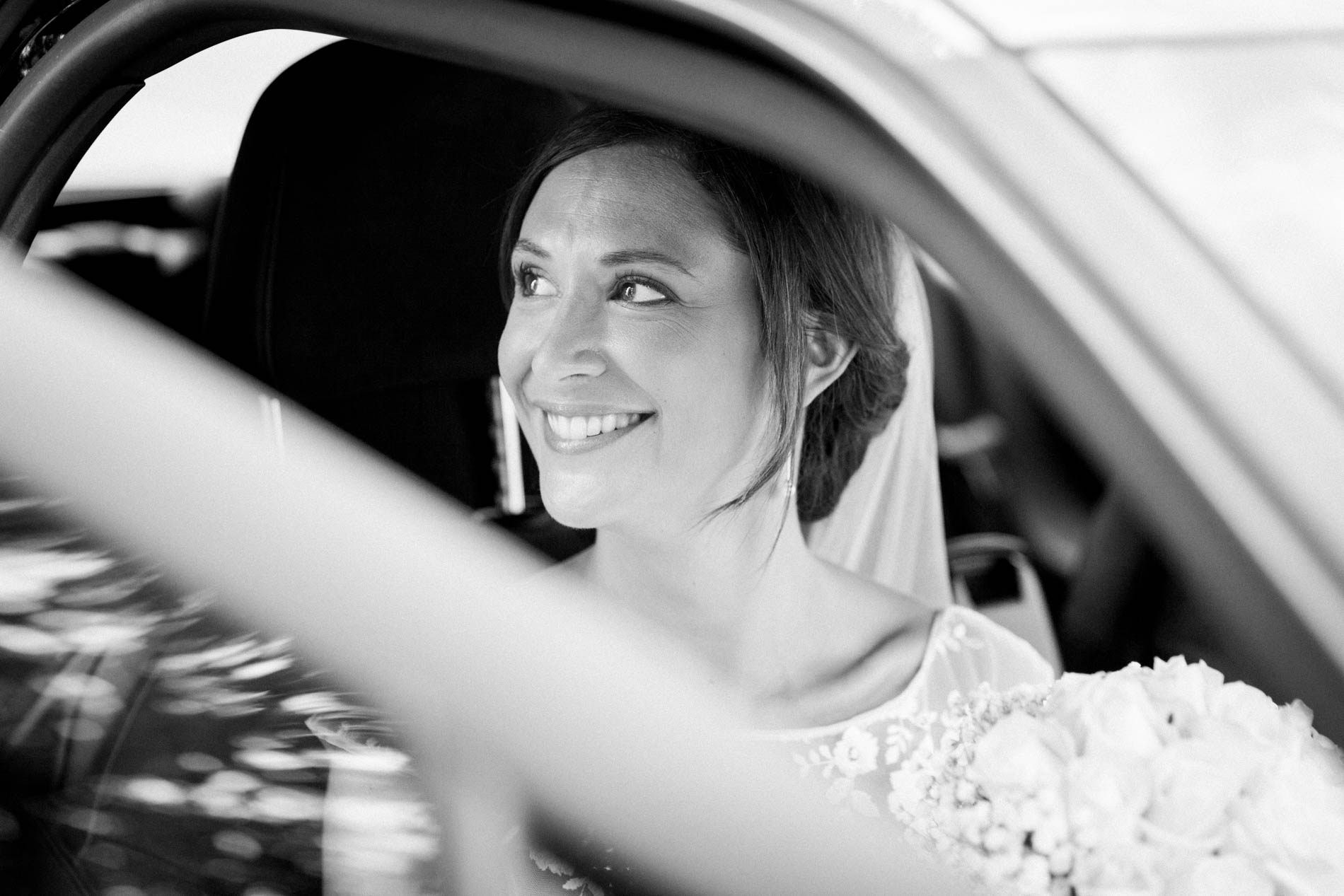 Bride gazing out of the car window, black and white photo