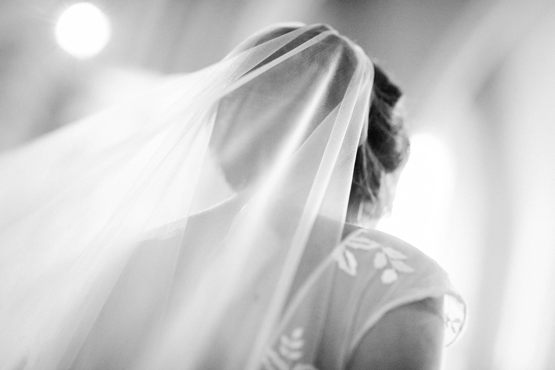 Bride's veil caught in the church light, in black and white