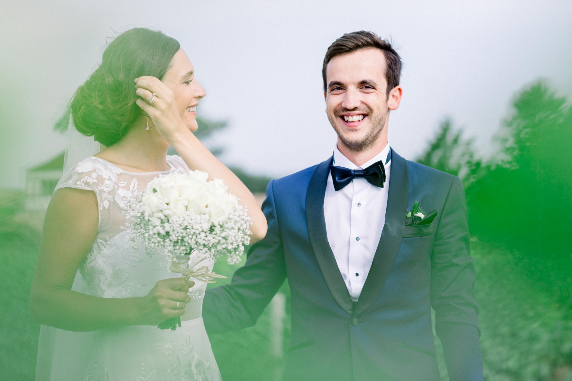 Bride and groom sharing a moment in the vines, groom in a blue suit