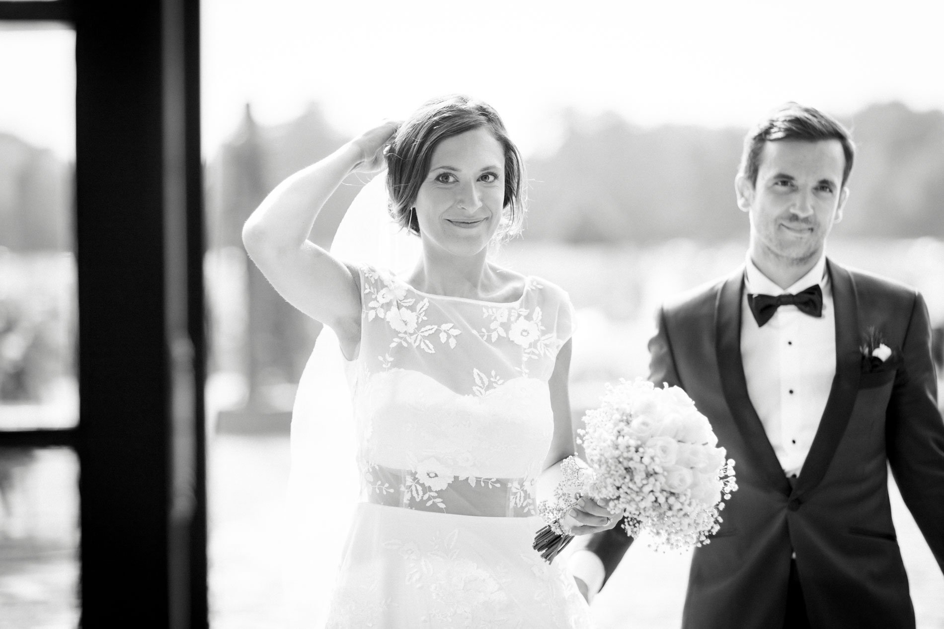 Bride fixing her hair beside the groom, black and white photo