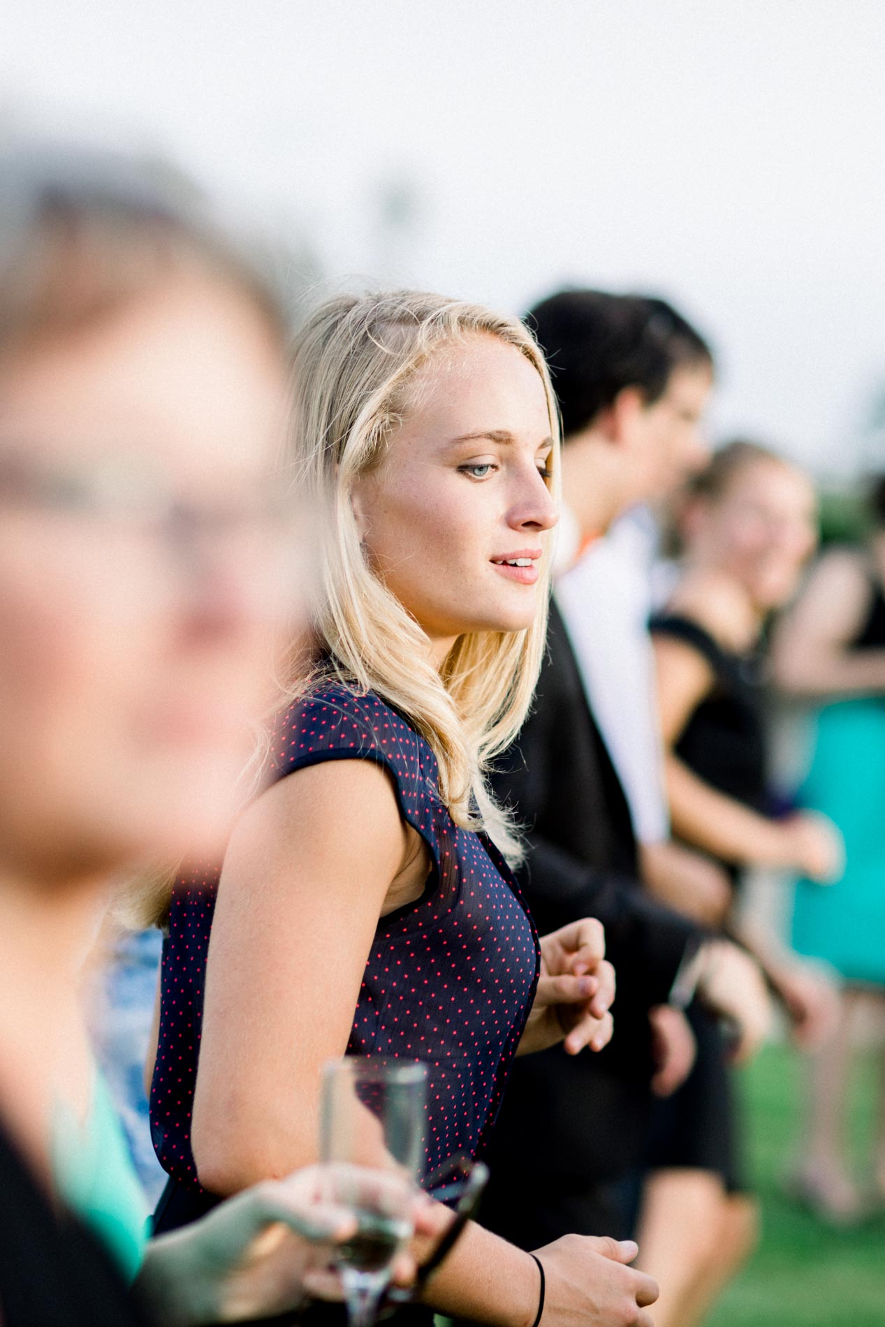 Blonde guest smiling with a glass of champagne at the drinks reception