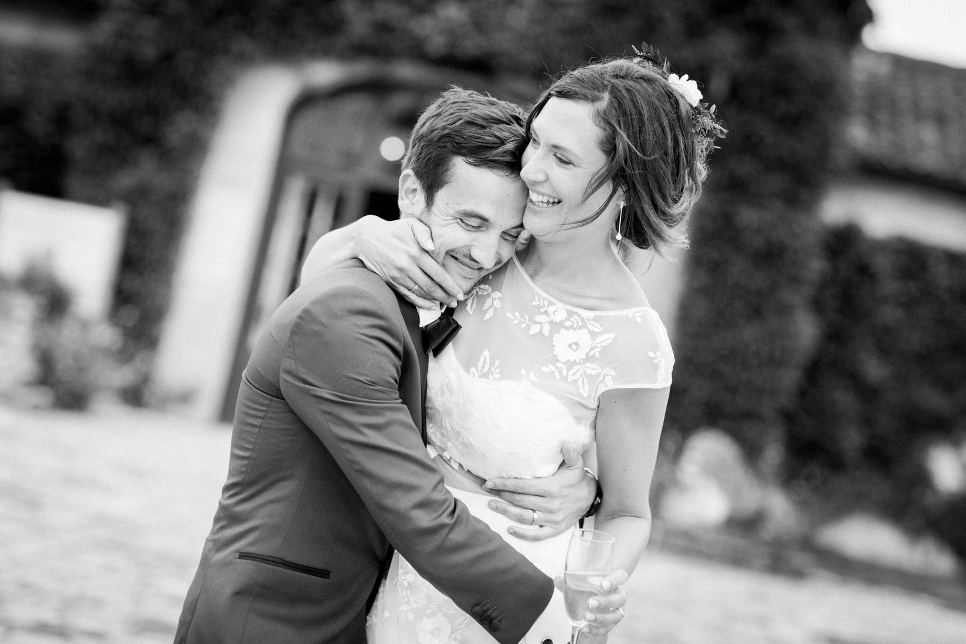 Groom holding the bride close in front of the château, black and white