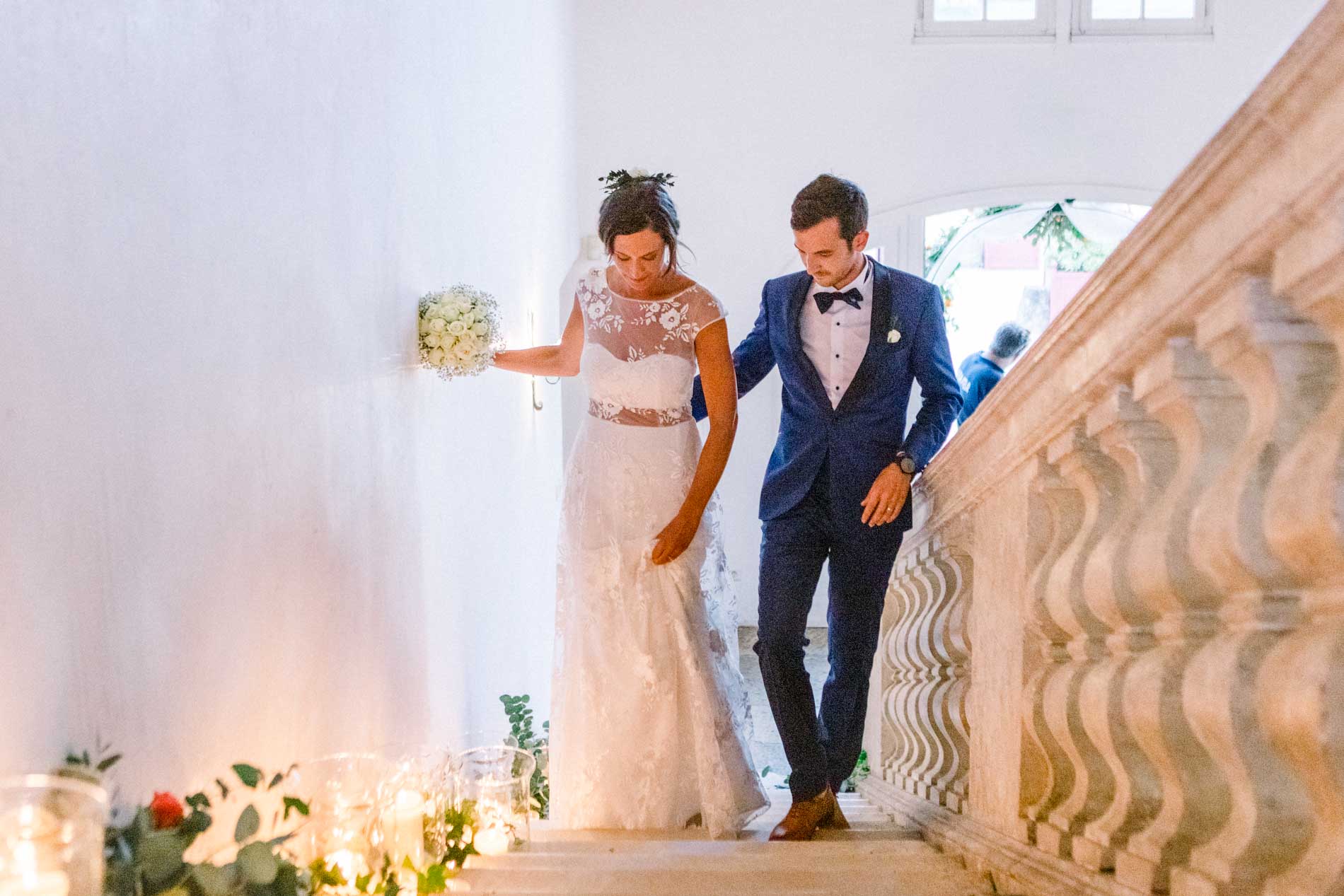 Bride and groom making their entrance down a candlelit staircase for dinner