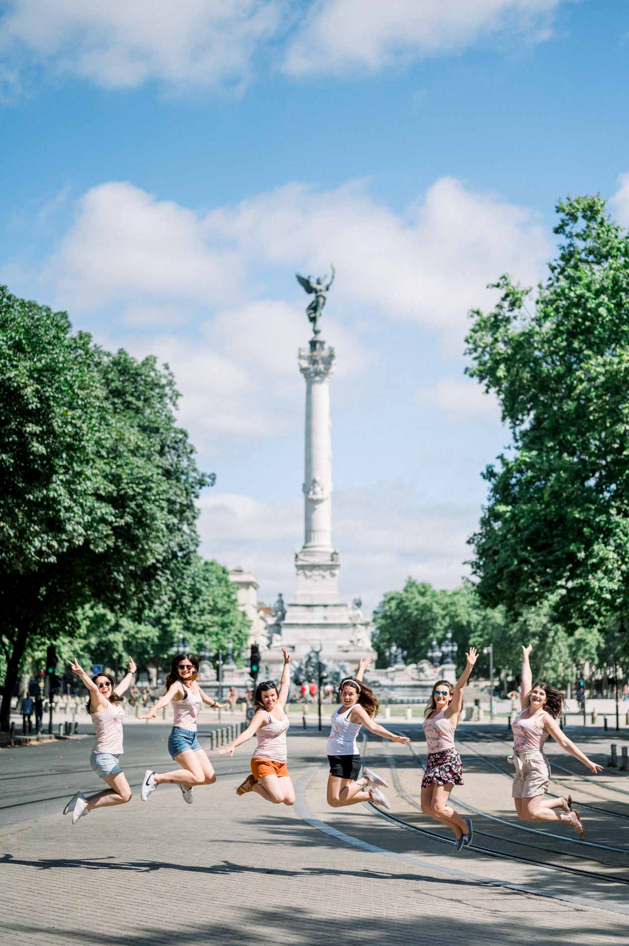 Amies sautant en l'air sur une place de Bordeaux pendant un EVJF