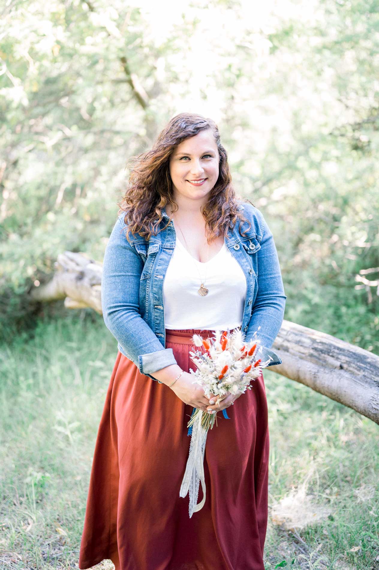 Portrait of a smiling young woman holding a dried flower bouquet