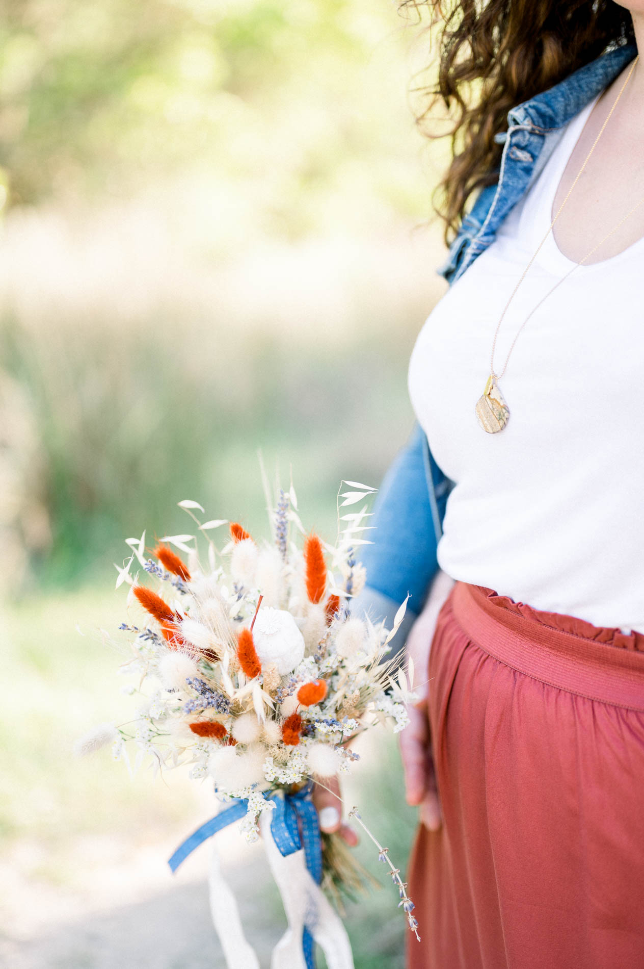 Detail of the dried flower bouquet and the young woman's gold necklace