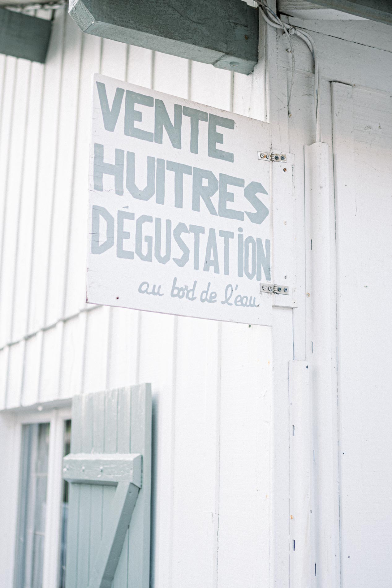 "Oysters for sale and tasting" sign on a hut in Le Canon village