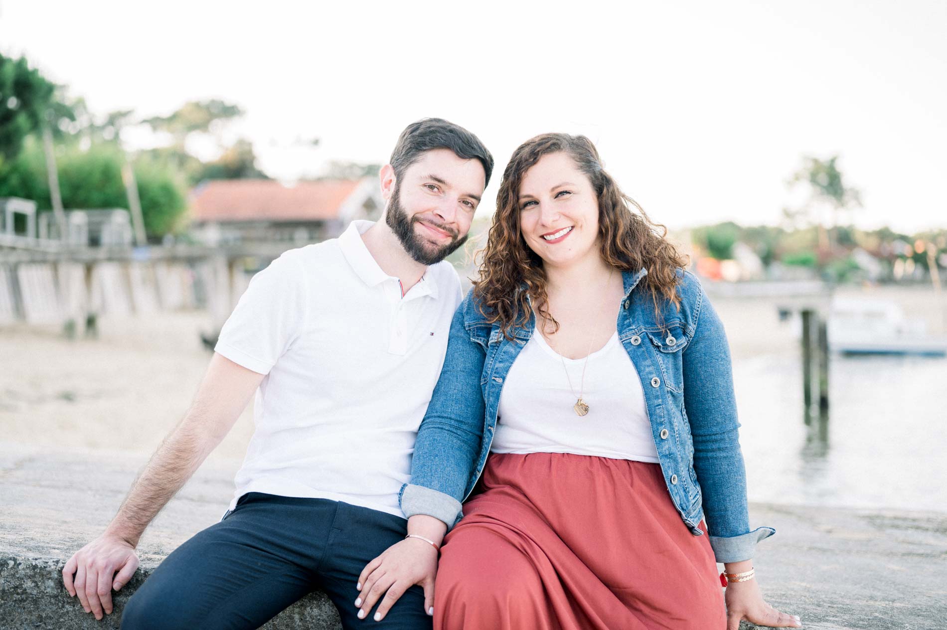 Couple sitting on a low wall at the edge of Arcachon Bay