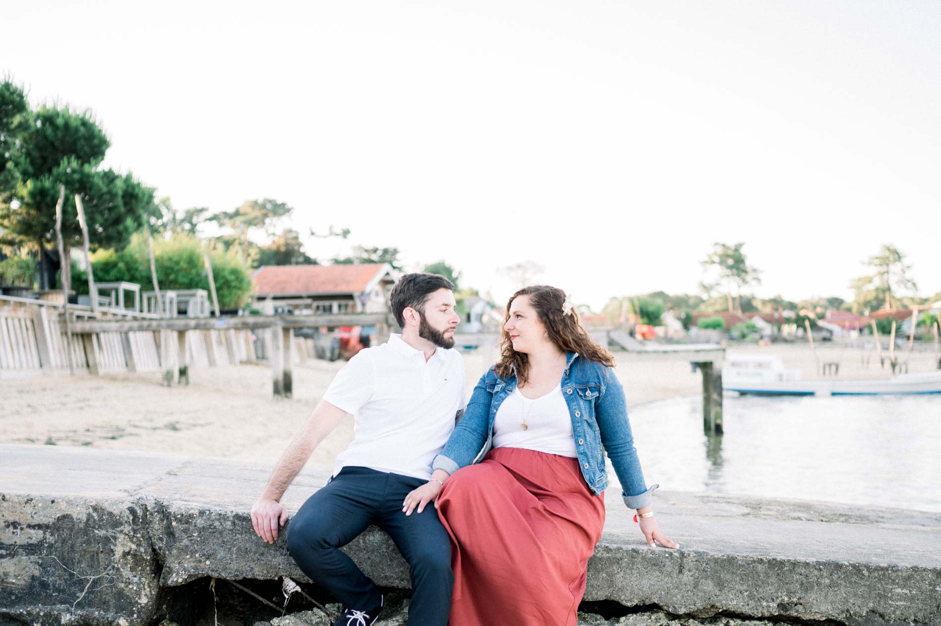 Seated couple smiling at each other by the Le Canon harbour, Cap Ferret