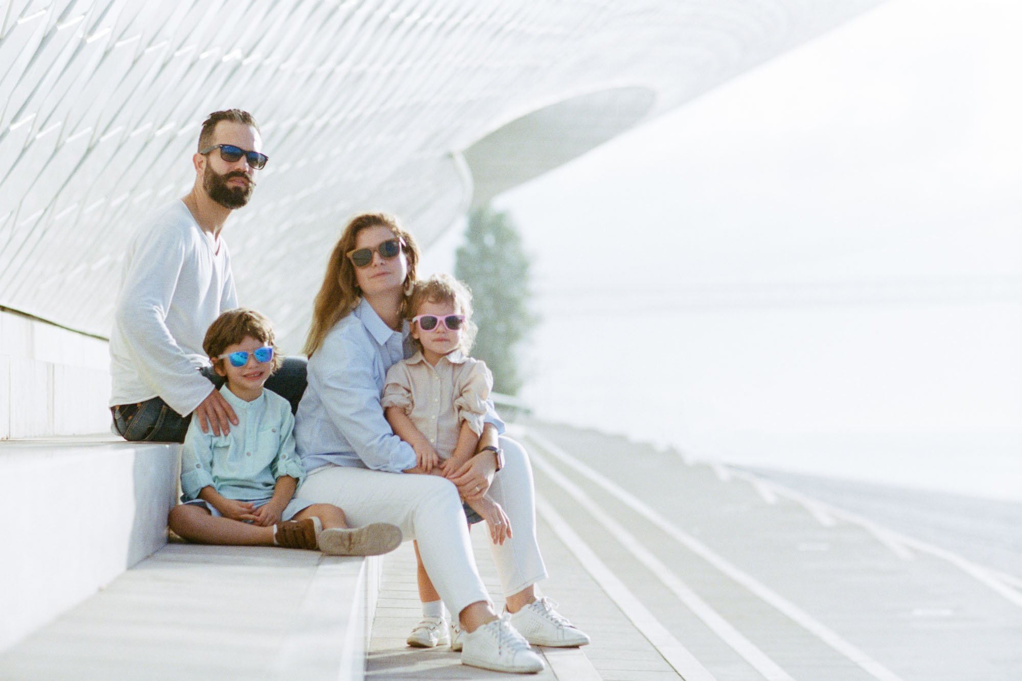 Famille assise sur des gradins blancs lors d'une séance photo à Lisbonne