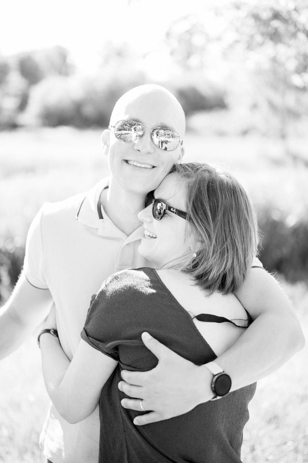 Parents embracing in sunglasses in the park, in black and white