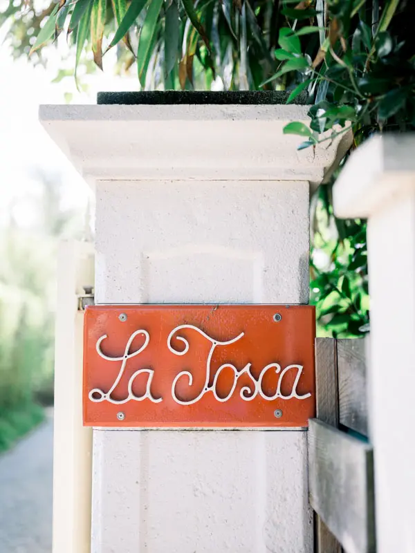 Red “La Tosca” name plate with white lettering at the entrance to the villa