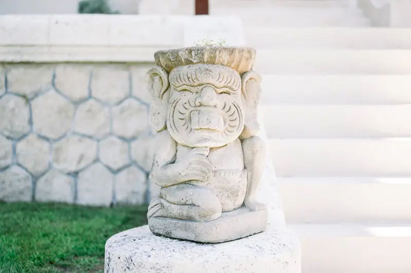 Small stone statue at the foot of the white staircase at Villa La Tosca