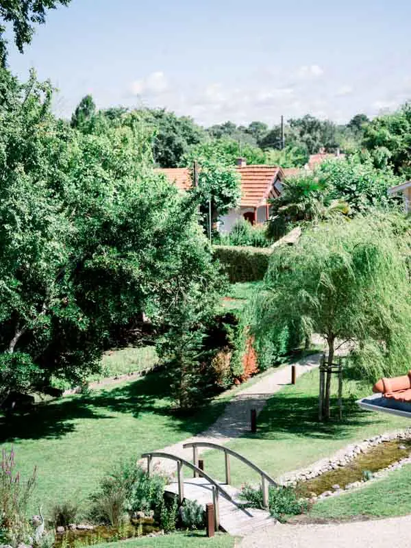 Leafy garden of Villa La Tosca with its little bridge and stream