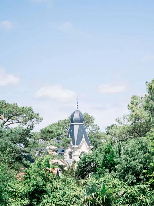 Roof and turret of a villa rising above the pines of Arcachon Bay