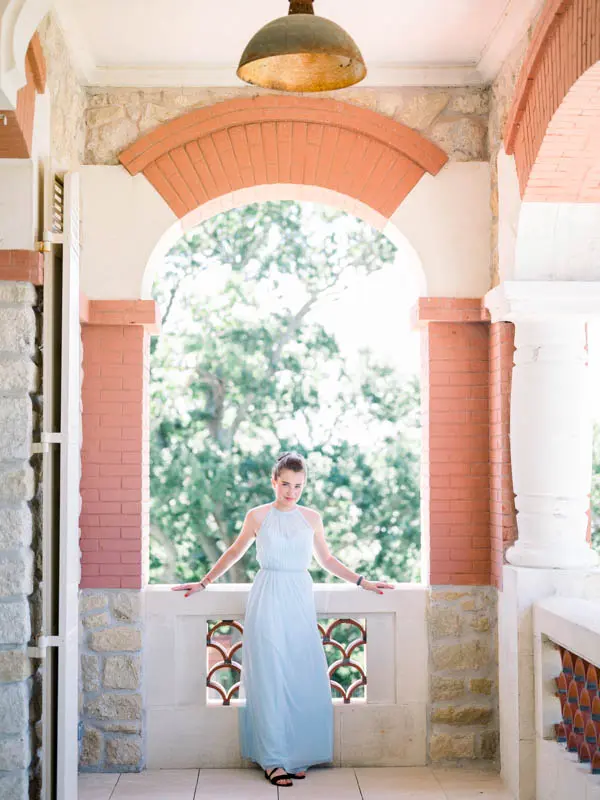 Guest in a pale blue dress beneath the pink arches of Villa La Tosca