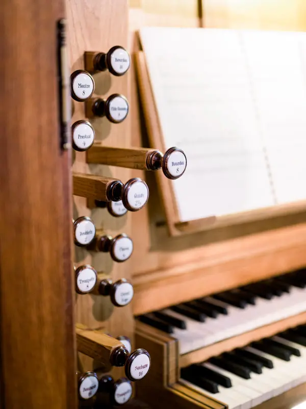 Organ stops and keyboard with open sheet music before the wedding mass