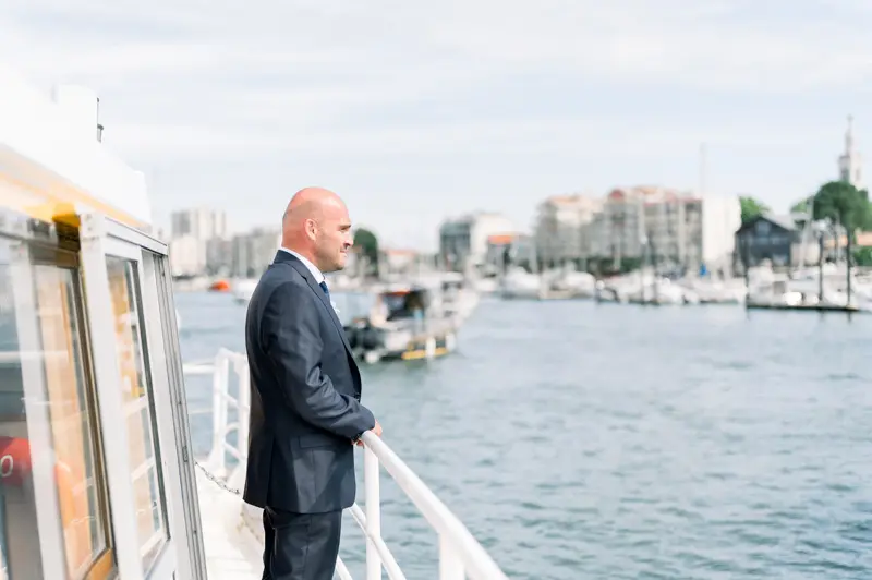 The groom leaning on the boat rail as it leaves Arcachon harbour