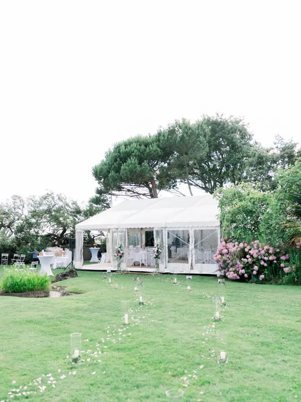 White reception marquee and petal-strewn aisle on the Villa La Tosca lawn