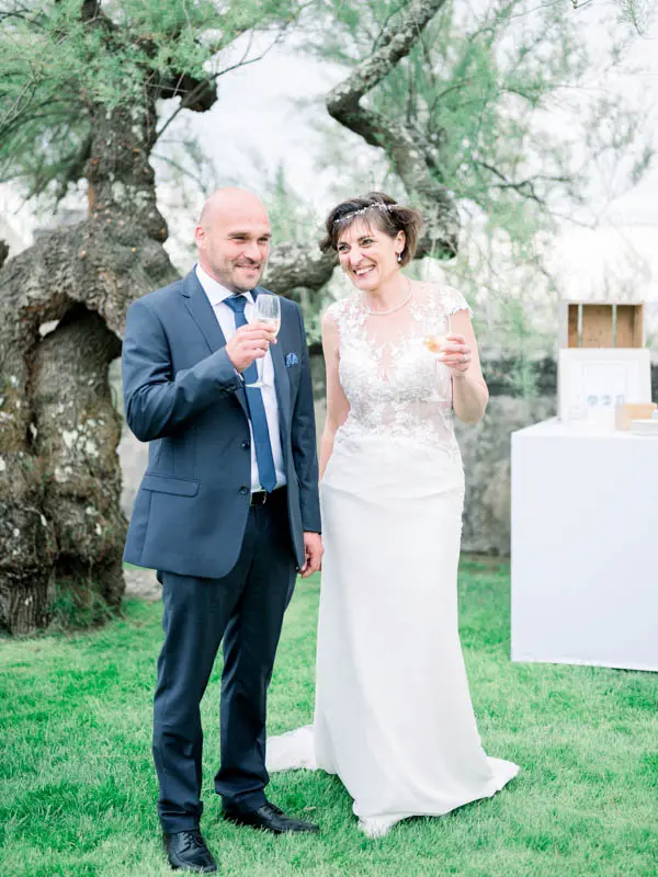 The bride and groom holding drinks during the cocktail hour in the villa garden