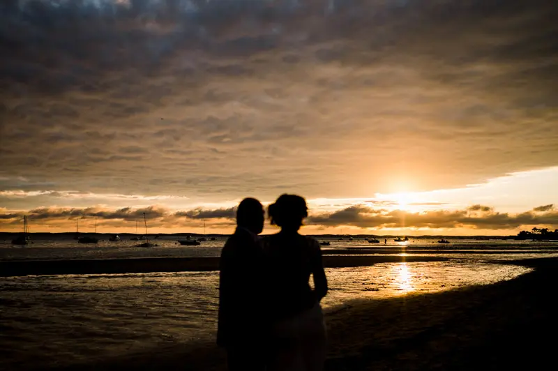 Silhouettes of the newlyweds facing the sunset over Arcachon Bay