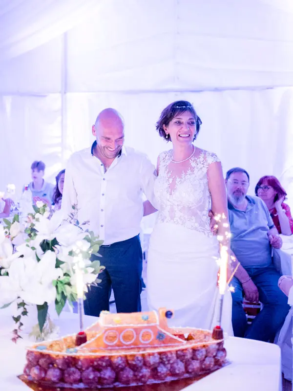 The bride and groom behind their wedding cake topped with sparklers