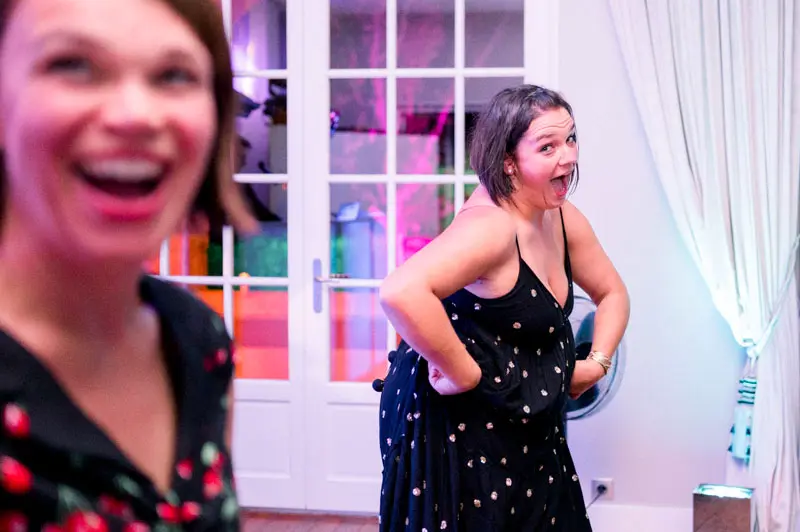 Two guests laughing heartily on the dance floor at the wedding party